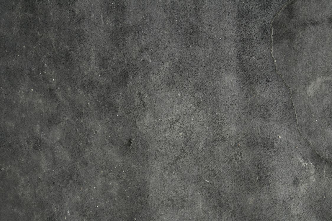 person in black shoes standing on gray concrete floor