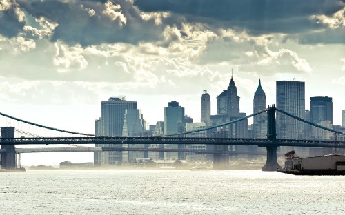 Image bridge over water near city buildings during daytime