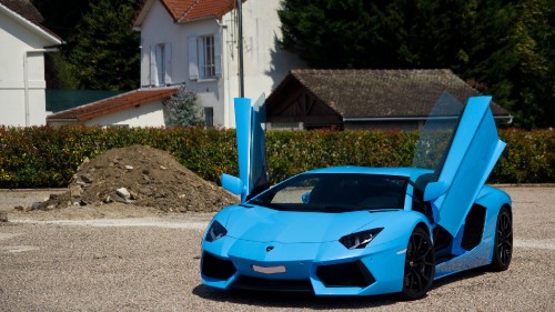 Image blue lamborghini aventador parked near white concrete building during daytime