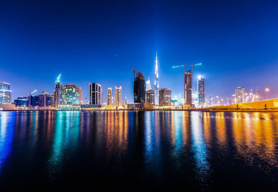 Skyline Der Stadt Über Gewässer Während Der Nacht. Wallpaper in 2667x1843 Resolution