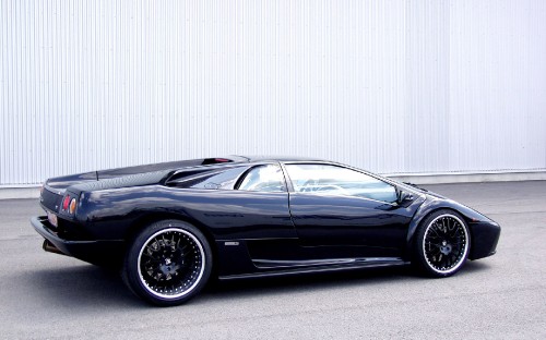 Image black porsche 911 parked near white wall