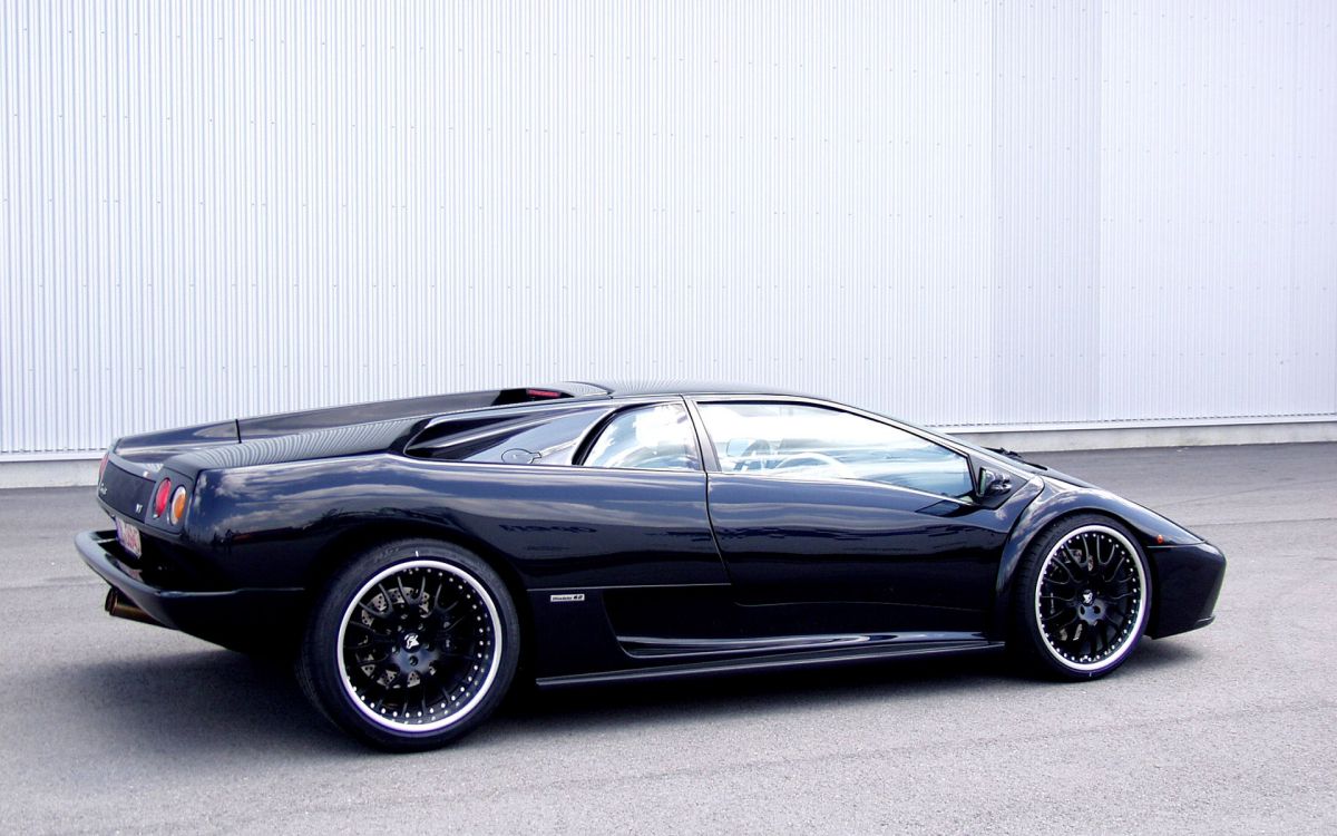 black porsche 911 parked near white wall