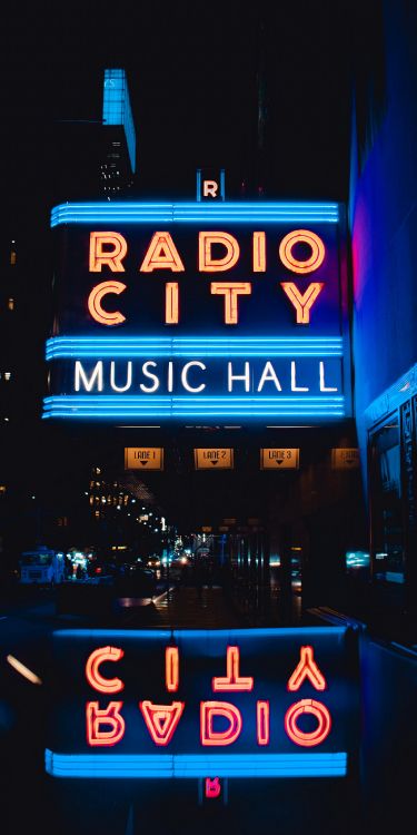 rockefeller center, radio city music hall, neon sign, text, building