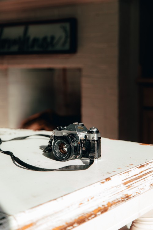 Image black and silver camera on white table