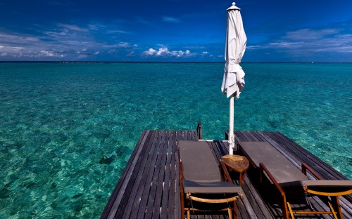 Image brown wooden dock on blue sea under blue sky during daytime