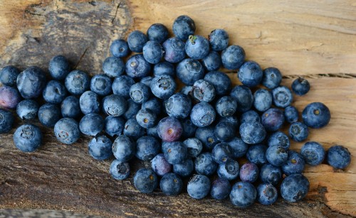 Image blue berries on brown wooden surface