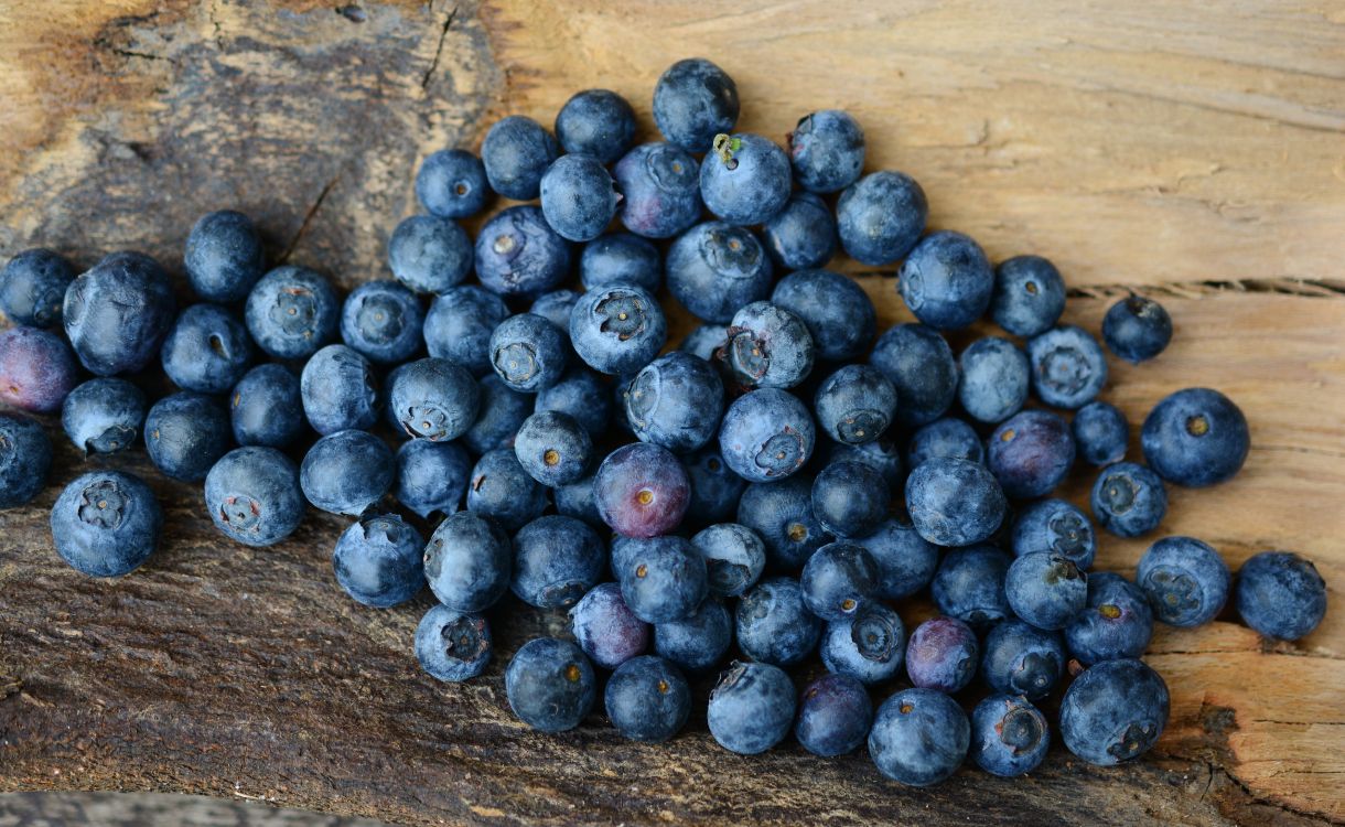 blue berries on brown wooden surface