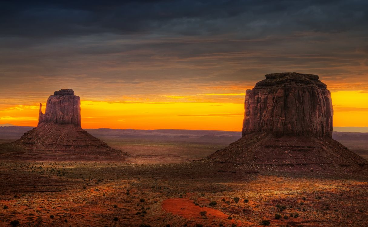 brown rock formation on brown sand during sunset