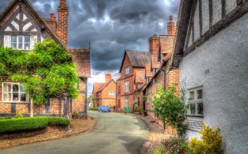 Image brown brick houses near green trees under cloudy sky during daytime