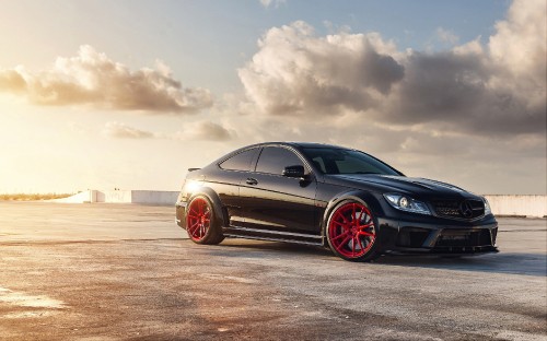 Image black coupe on brown field under white clouds during daytime