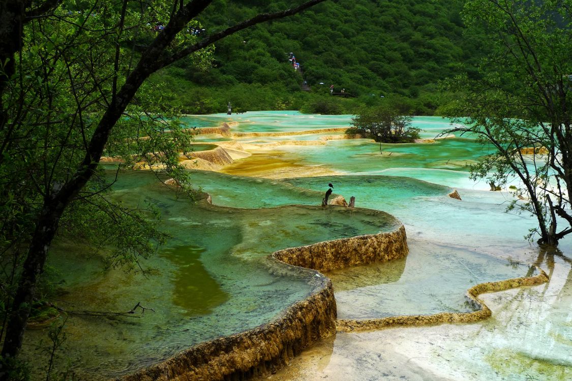 Frau in Schwarzem Hemd Und Schwarzer Hose, Die Tagsüber Auf Einem Felsen in Der Nähe Eines Gewässers Steht. Wallpaper in 2700x1800 Resolution