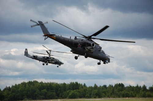 Image black and gray fighter plane flying over green trees during daytime