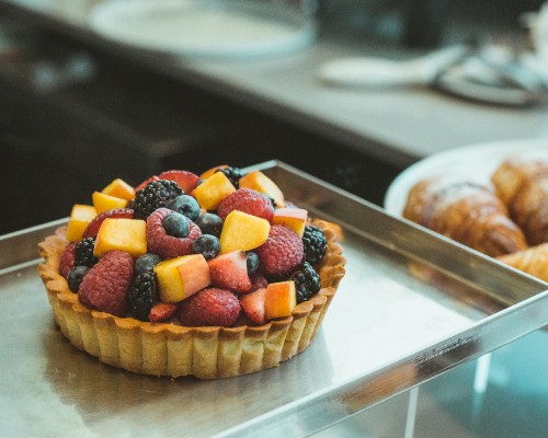 Image brown cupcake with assorted fruits on top