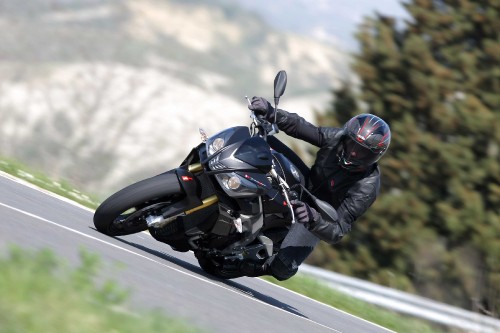 Image man in black jacket riding black sports bike