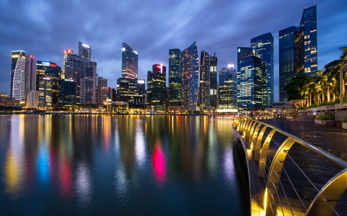 Image city skyline across body of water during night time