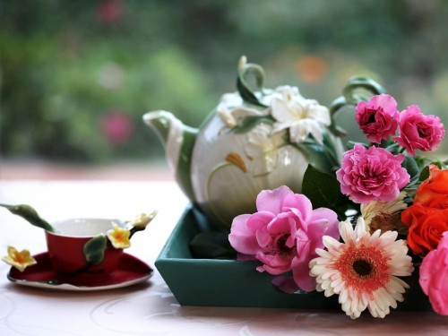 Image pink and white flowers in white ceramic teapot