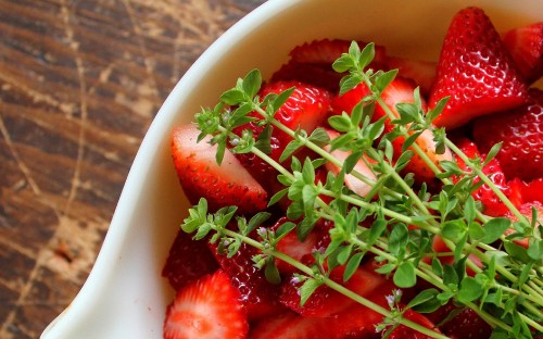 Image sliced strawberries in white ceramic bowl