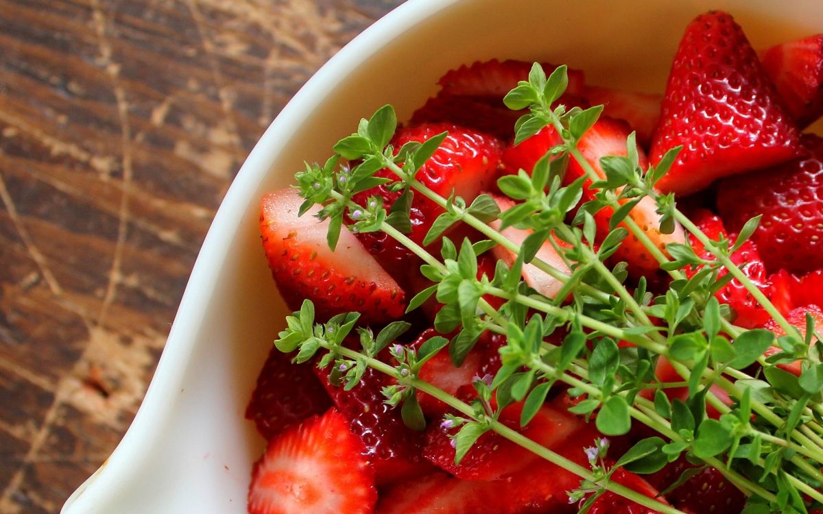 sliced strawberries in white ceramic bowl