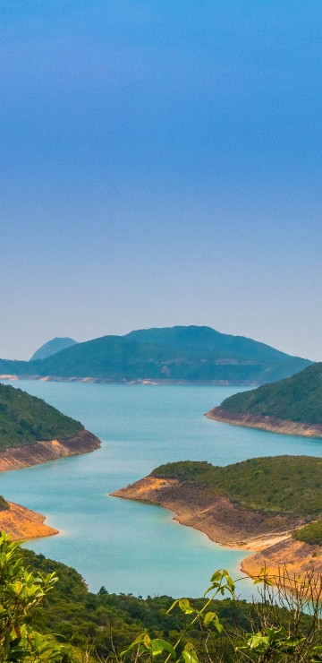 Image green mountains near body of water during daytime