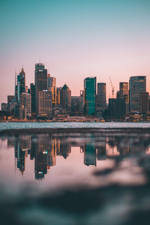 Image city skyline across body of water during night time