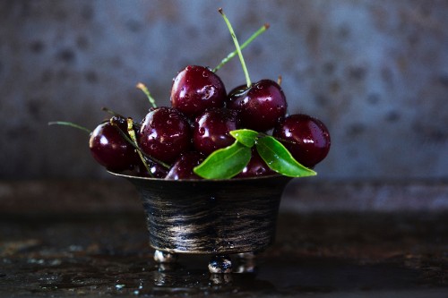 Image red cherries in black ceramic bowl