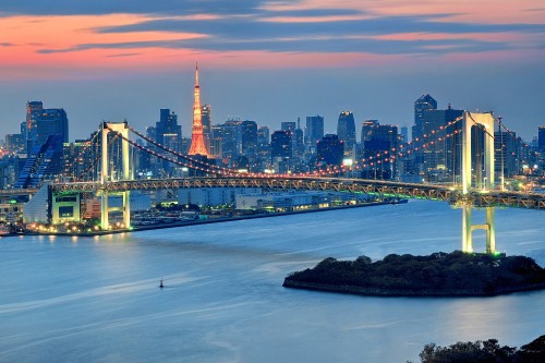 Image bridge over water near city skyline during night time