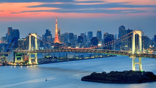 Image bridge over water near city skyline during night time