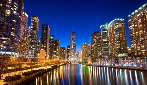 Image city skyline across body of water during night time