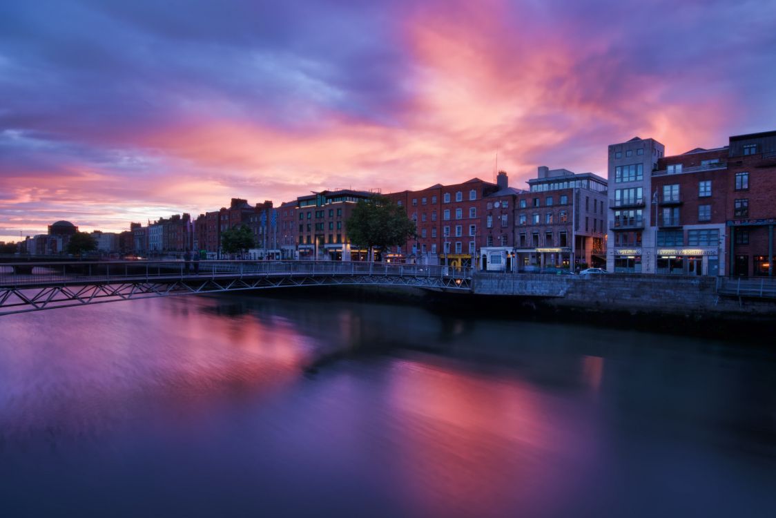 city skyline near body of water during sunset