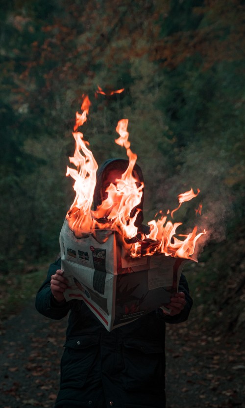 Image person in black jacket holding fire