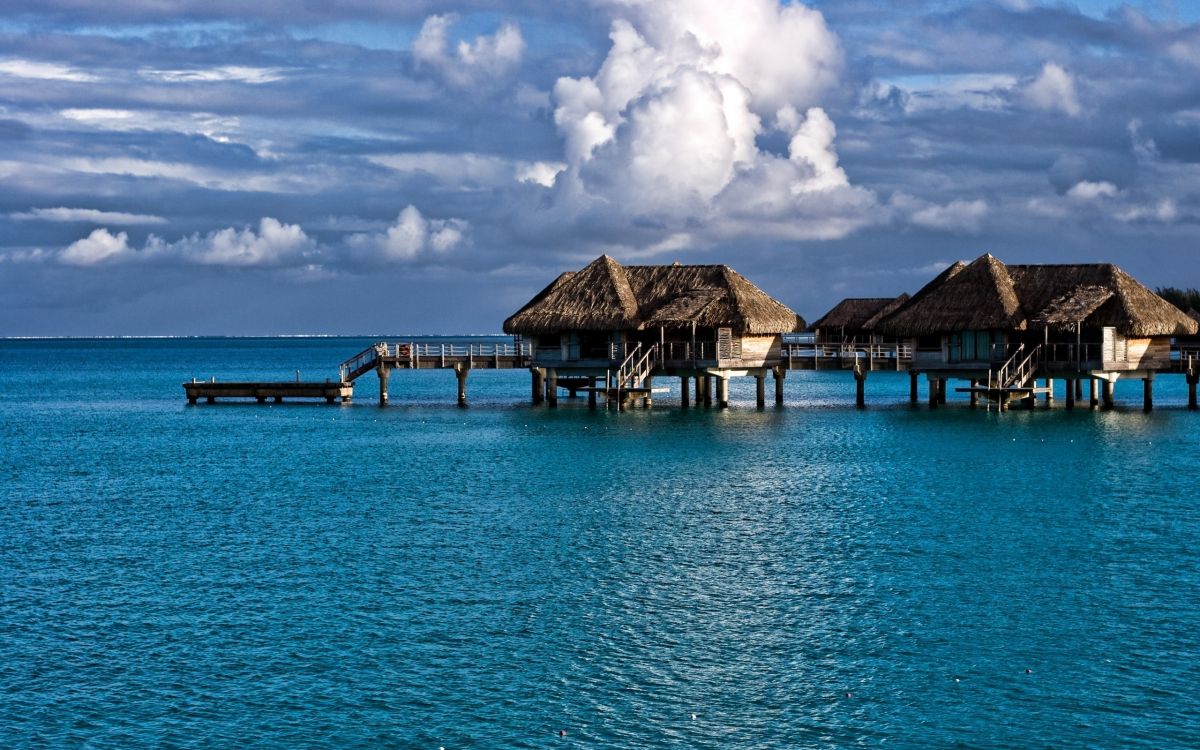 Casas de Madera Marrón en el Mar Azul Bajo un Cielo Azul Durante el Día. Wallpaper in 2560x1600 Resolution