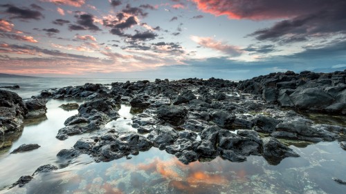 Image rocky shore under cloudy sky during daytime