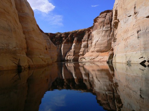 Image brown rock formation near body of water under blue sky during daytime