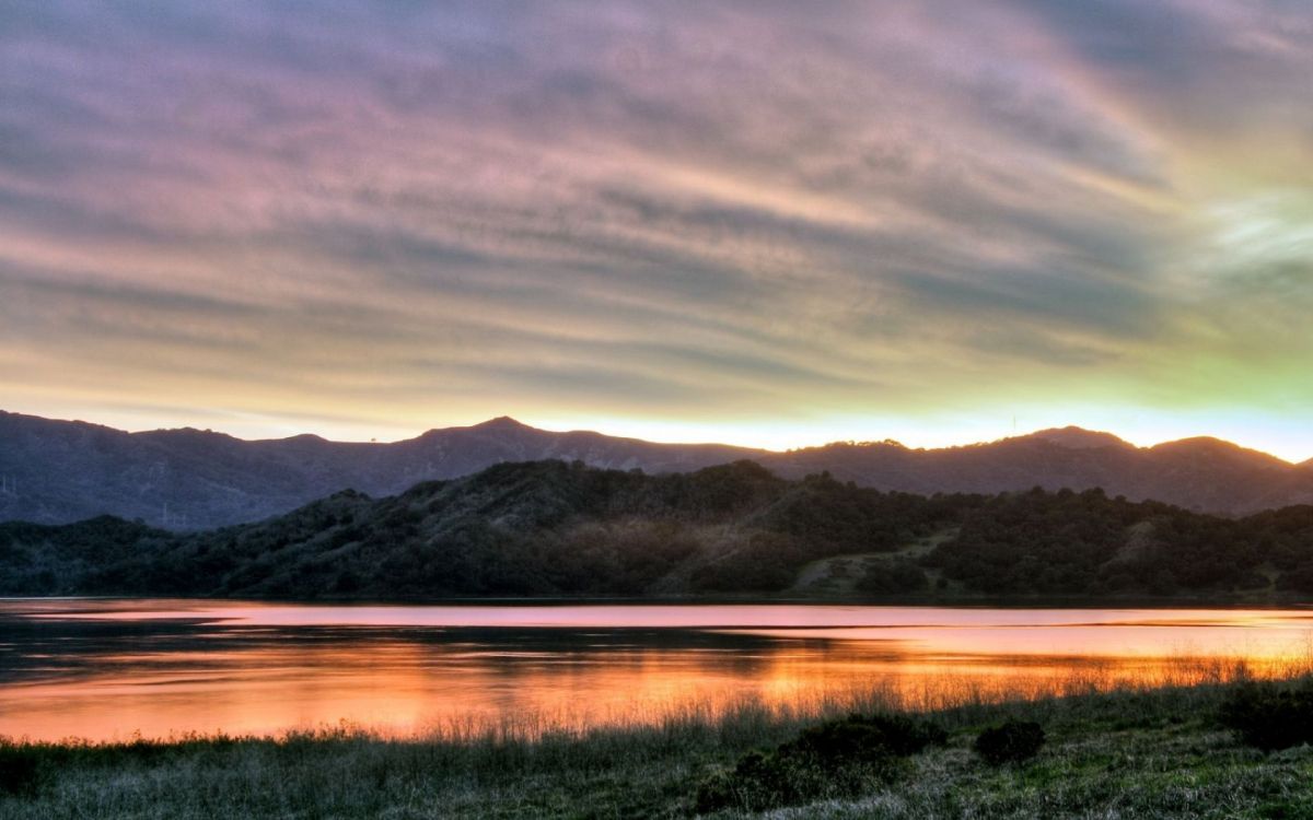 Campo de Hierba Verde Cerca Del Lago y Las Montañas Durante el Día. Wallpaper in 1920x1200 Resolution