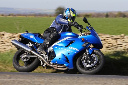 Image man in black helmet riding blue and black sports bike