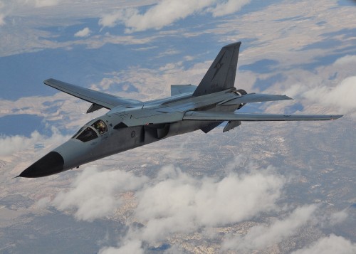 Image black fighter jet flying over white clouds during daytime