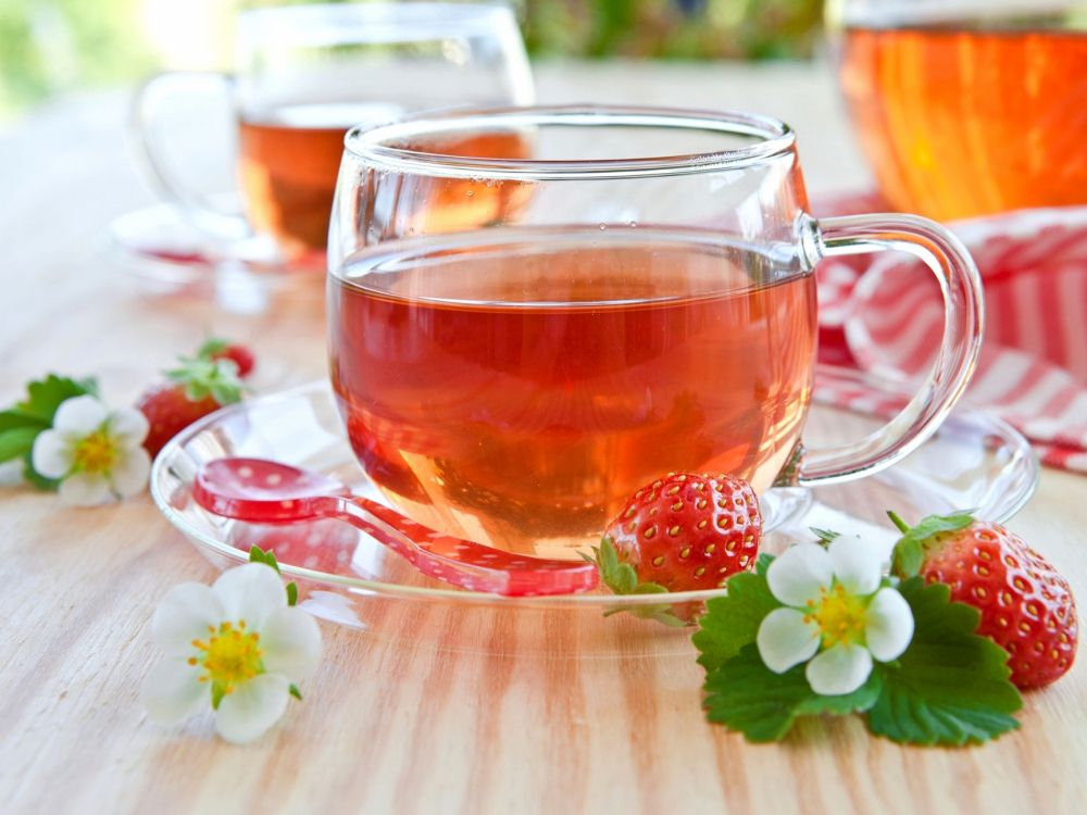 clear glass teacup with red liquid