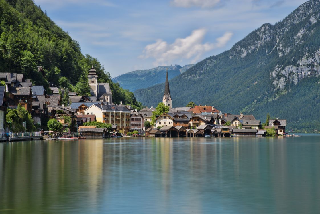 houses near lake and mountain during daytime