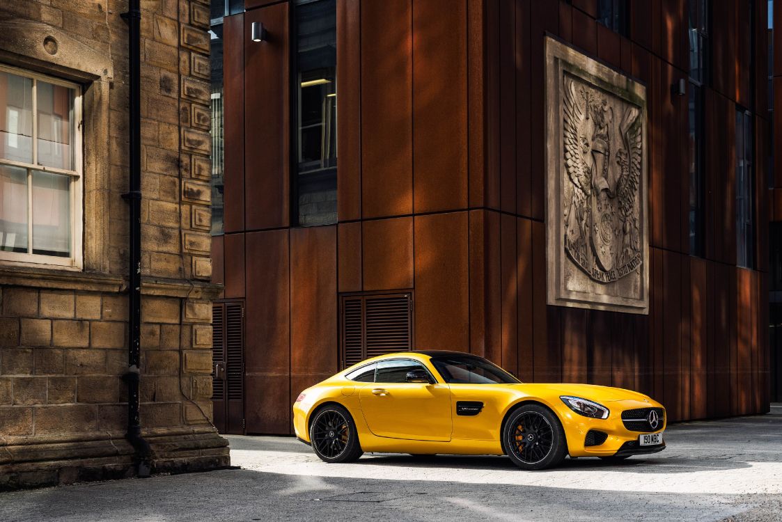 Porsche 911 Amarillo Estacionado Junto al Edificio de Hormigón Marrón Durante el Día. Wallpaper in 4096x2734 Resolution