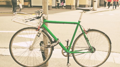 Image green bicycle parked on sidewalk during daytime