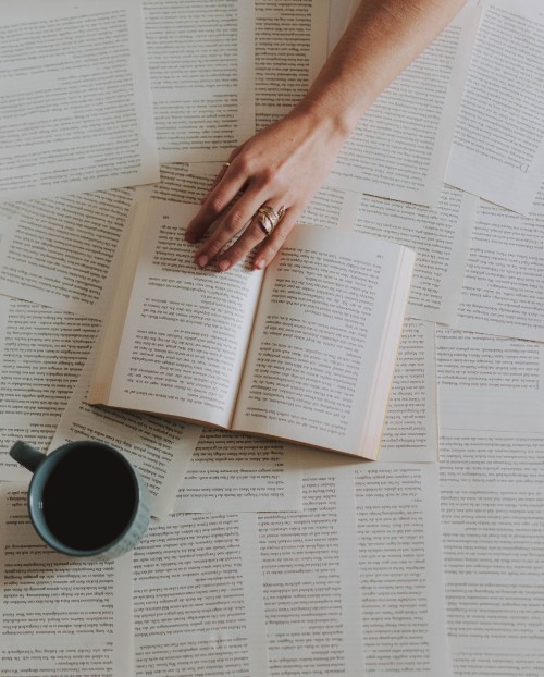 Image person holding white ceramic mug on white book page