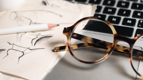 Image brown and black framed eyeglasses on white printer paper