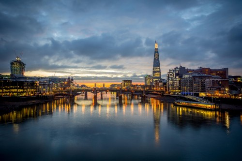 Image city skyline across body of water during night time