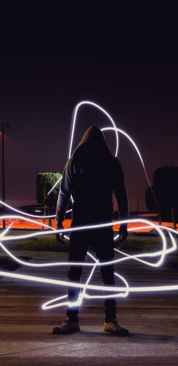 Image man in black jacket and pants standing on road during night time