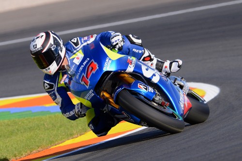 Image man in red and white racing suit riding on blue and red sports bike