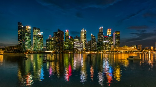 Image city skyline across body of water during night time