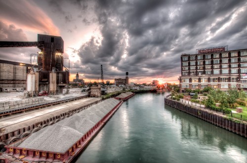 Image body of water near buildings under cloudy sky during daytime