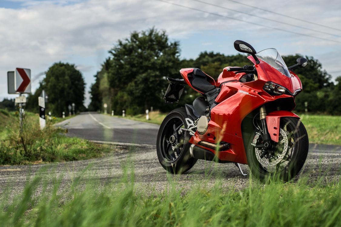 red and black sports bike on road during daytime