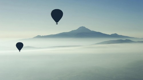 Image blue hot air balloon flying over the mountains during daytime