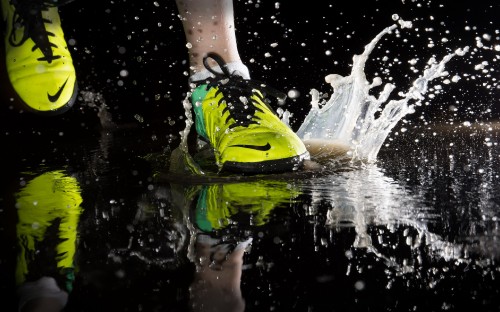 Image person in green and black nike athletic shoes on water